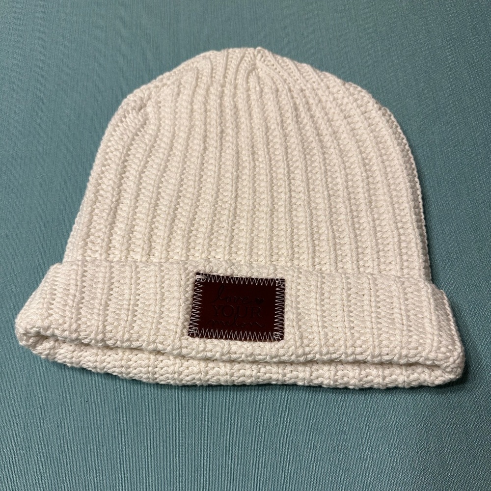 White Love Your Melon cuffed beanie with brown patch.